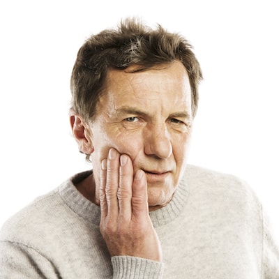 Headshot of an older man in pain and in need of a root canal.