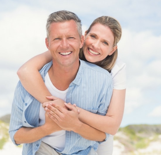 A smiling couple who are free from tooth pain after root canal therapy