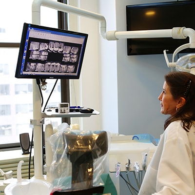 A dentist looking at xrays in preparation for All-on-four dental implants in Lennox Hill New York